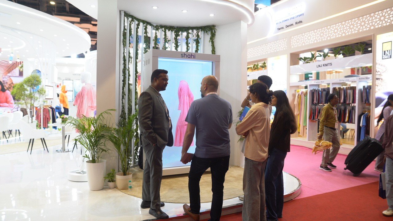 A life-size HoloBox display showing apparel at a fashion trade show booth