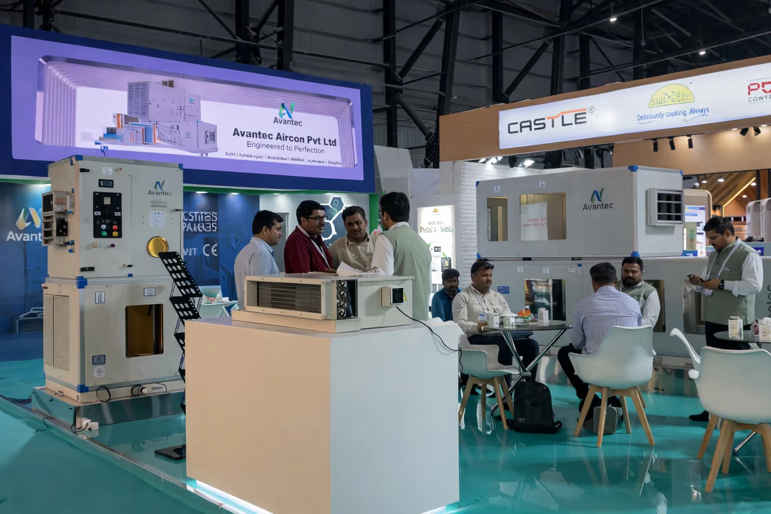 Trade show booth of Avantec Aircon Pvt Ltd featuring industrial air conditioning units and people discussing and seated at tables.