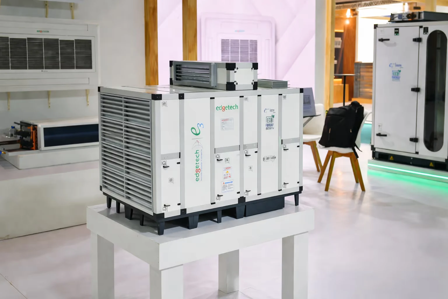 Edgetech air handling unit displayed on a white stand in a showroom with other HVAC equipment in the background.