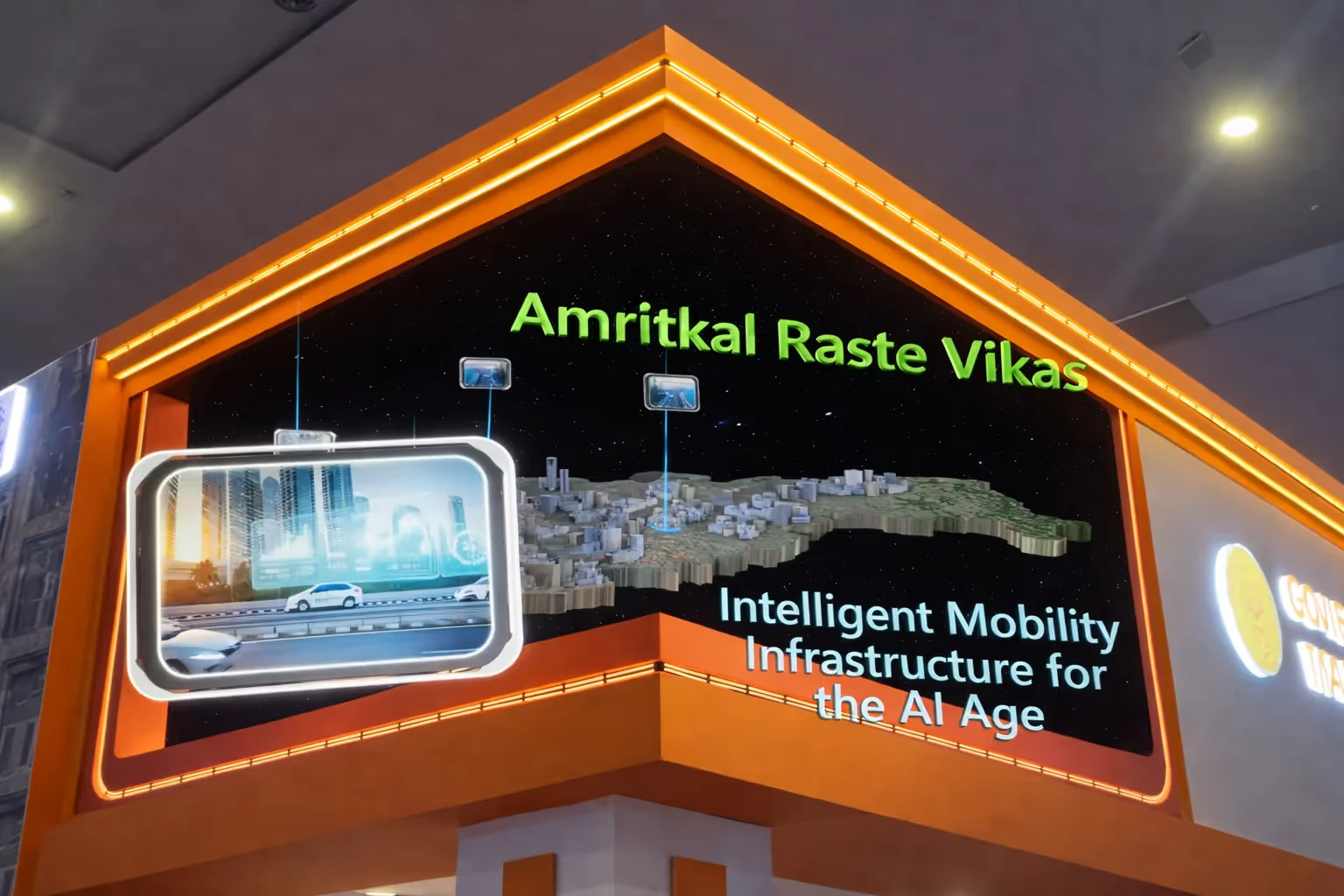 Exhibition display with text 'Amritkal Raste Vikas' and 'Intelligent Mobility Infrastructure for the AI Age' accompanied by a 3D city model and digital road imagery.
